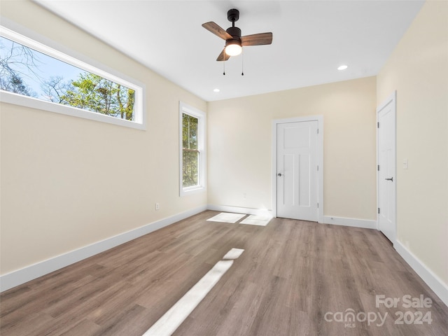 unfurnished room with ceiling fan, a wealth of natural light, and light hardwood / wood-style floors