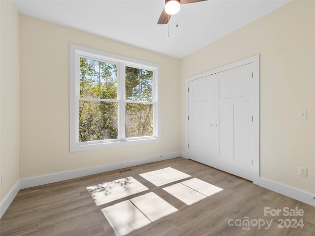 unfurnished bedroom with ceiling fan and light hardwood / wood-style flooring