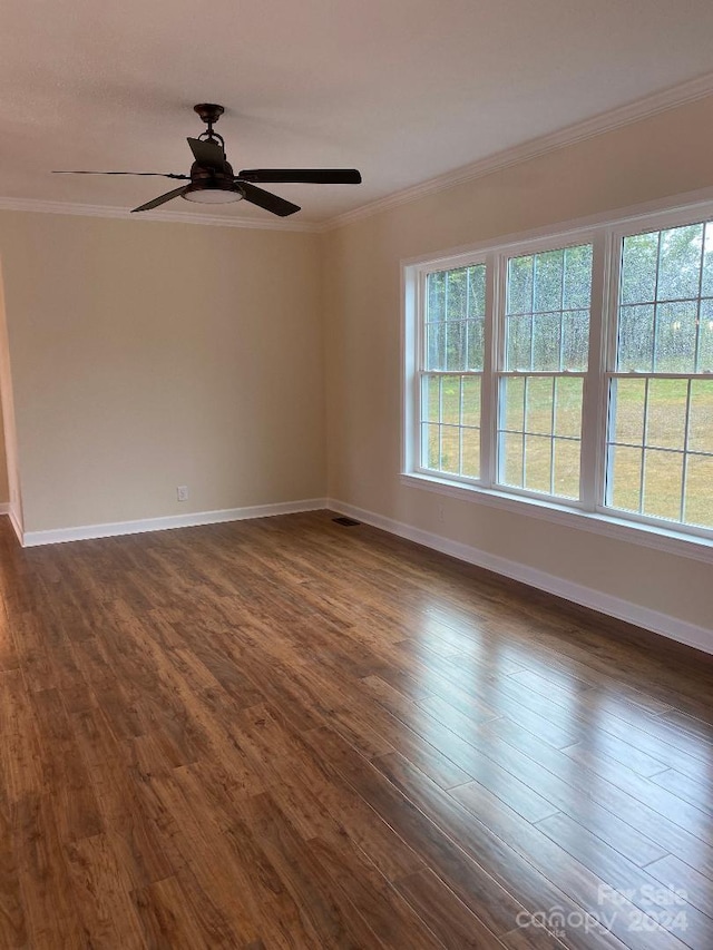 spare room featuring crown molding, dark wood-type flooring, and ceiling fan