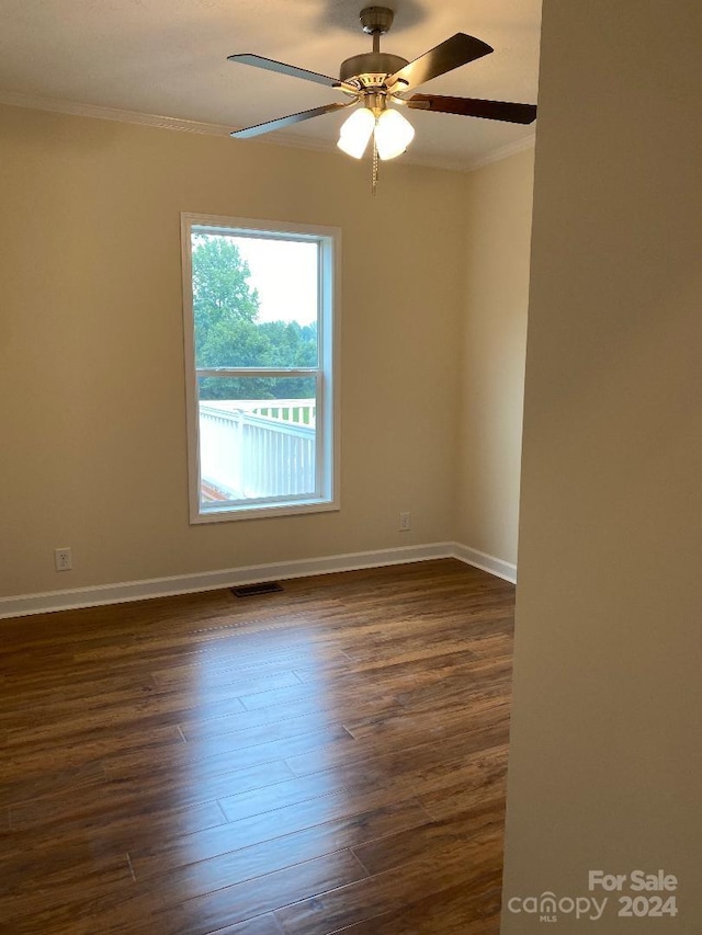 spare room featuring crown molding, ceiling fan, and dark hardwood / wood-style floors