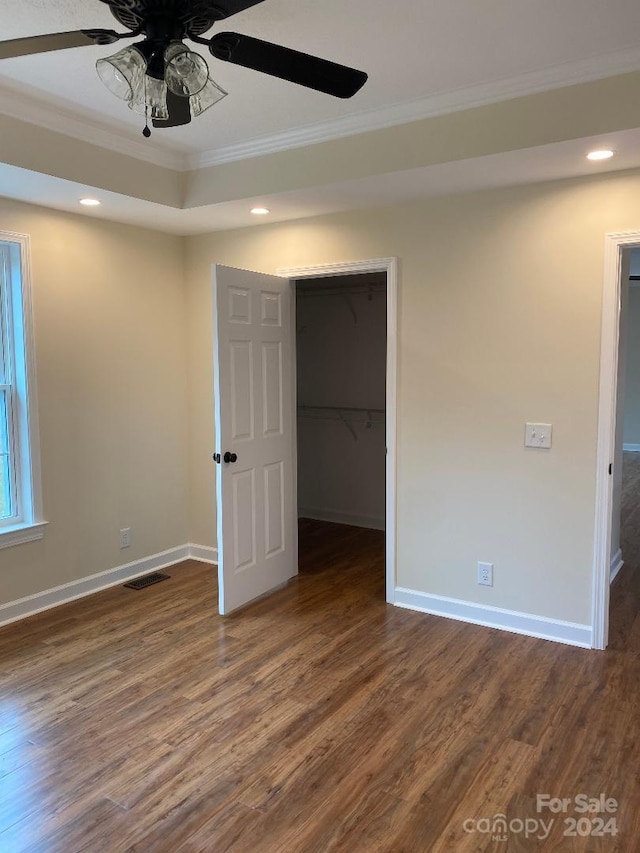 empty room featuring ceiling fan, crown molding, and dark hardwood / wood-style floors