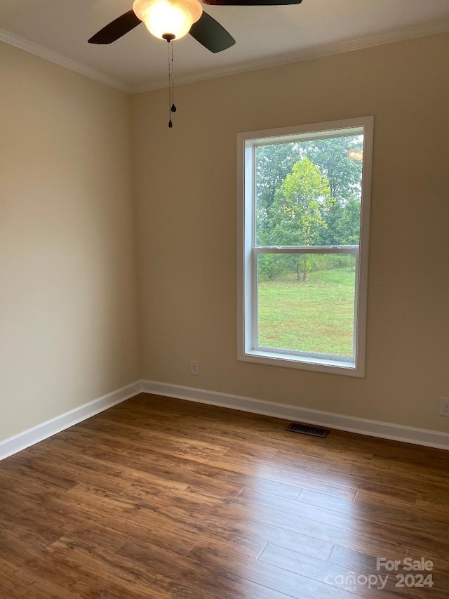 spare room with ornamental molding, ceiling fan, a wealth of natural light, and dark hardwood / wood-style floors