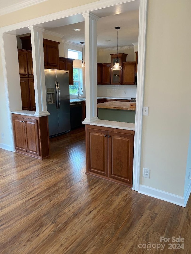 kitchen with dark hardwood / wood-style floors, tasteful backsplash, decorative light fixtures, and stainless steel fridge