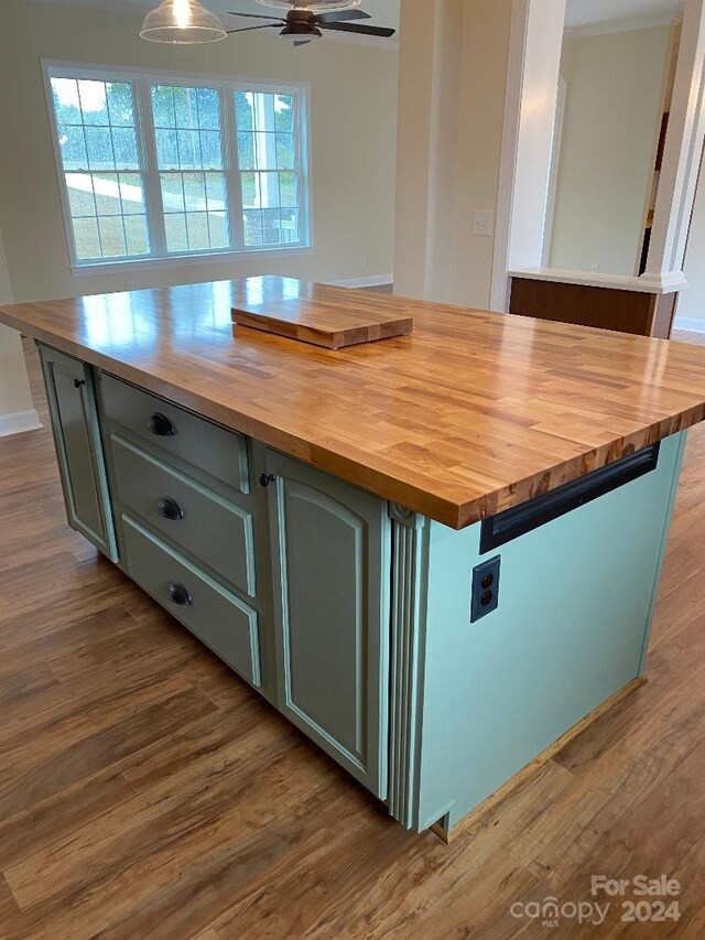 kitchen featuring plenty of natural light, ceiling fan, hardwood / wood-style flooring, wooden counters, and a center island