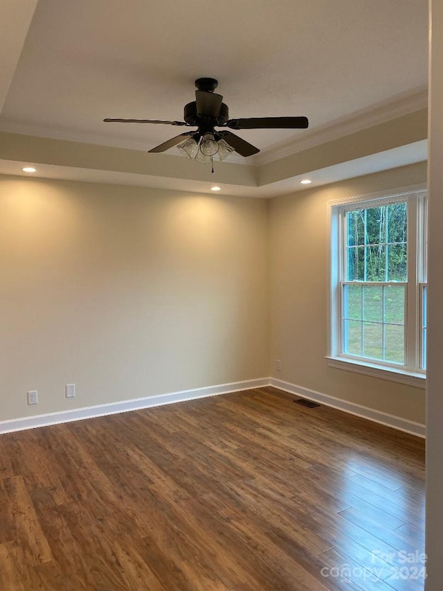 spare room featuring ornamental molding, ceiling fan, and dark wood-type flooring