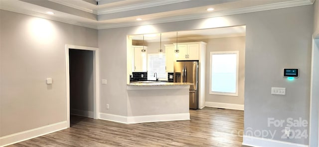 kitchen featuring hardwood / wood-style flooring, stainless steel fridge, light stone counters, and white cabinetry