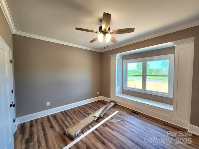 empty room featuring ornamental molding, dark wood-style flooring, and a ceiling fan