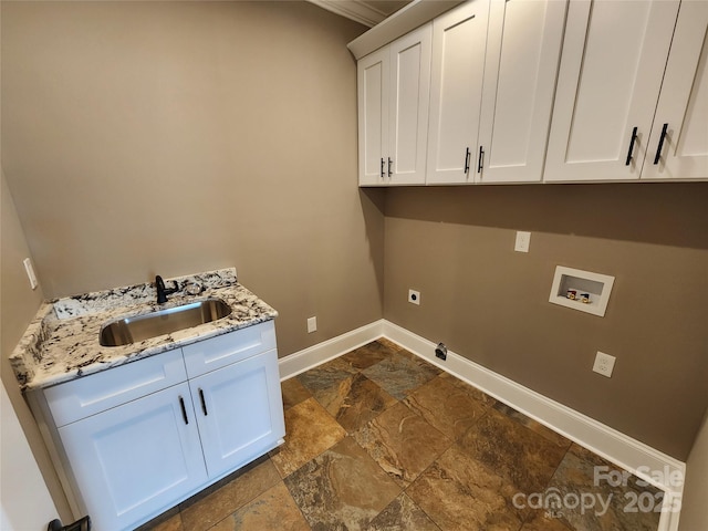 laundry area featuring stone finish floor, a sink, baseboards, cabinet space, and washer hookup