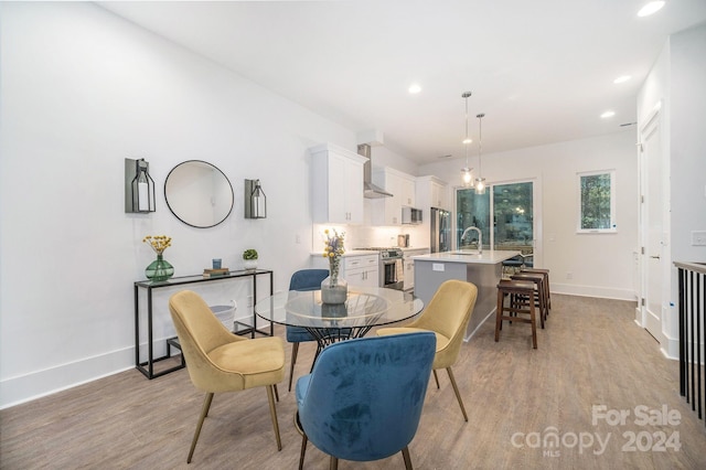 dining space featuring sink and light hardwood / wood-style floors