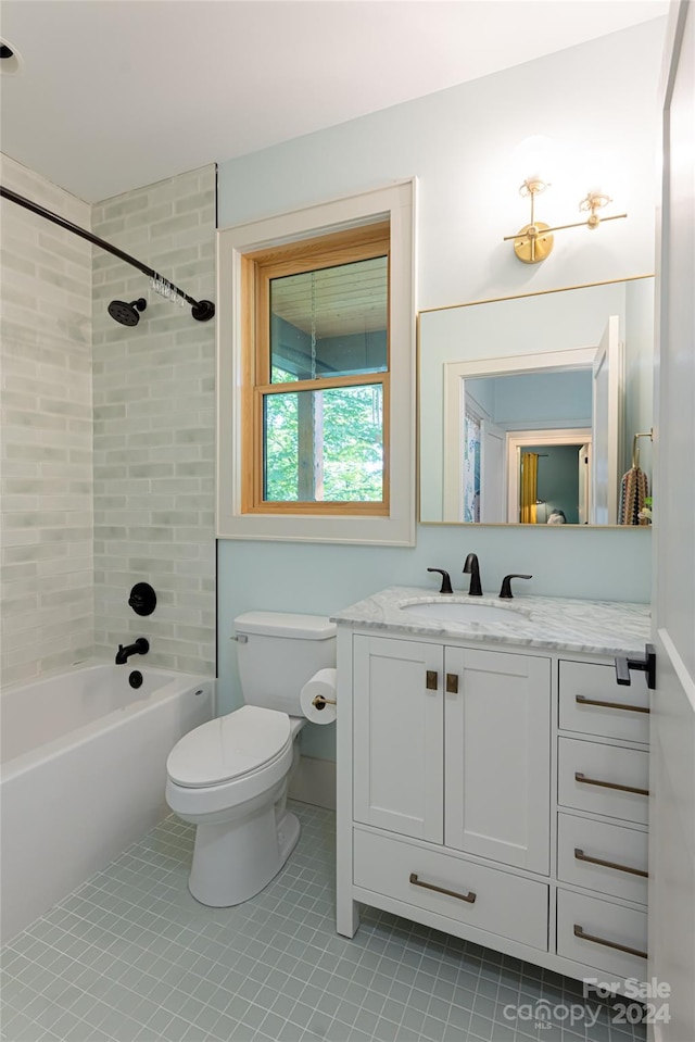 full bathroom with vanity, tiled shower / bath combo, toilet, and tile patterned flooring