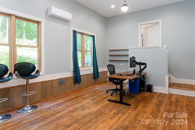 office space with a wall unit AC, dark wood-type flooring, and a wealth of natural light