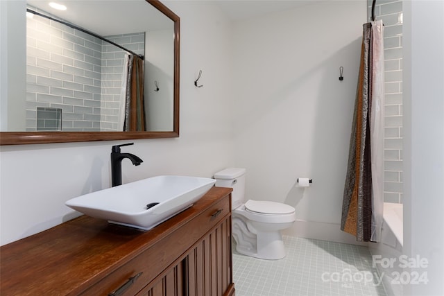 full bathroom with vanity, toilet, shower / bath combo with shower curtain, and tile patterned flooring