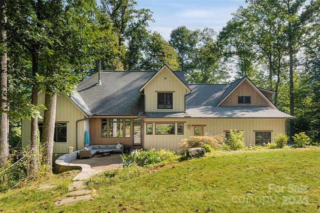 back of property featuring an outdoor living space, a lawn, and a patio area