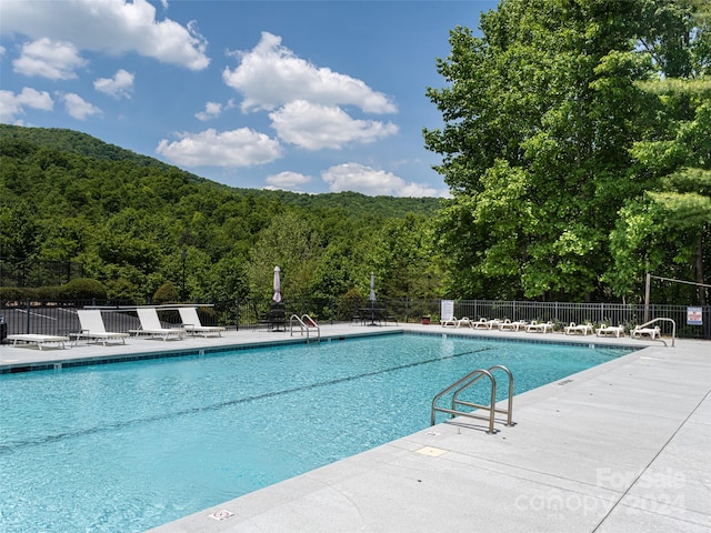 view of swimming pool featuring a patio area and a mountain view