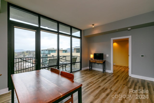 dining space featuring floor to ceiling windows and hardwood / wood-style floors