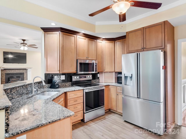 kitchen featuring kitchen peninsula, backsplash, ceiling fan, stainless steel appliances, and dark stone counters