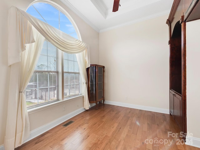 unfurnished room featuring light hardwood / wood-style flooring, a raised ceiling, ceiling fan, and crown molding