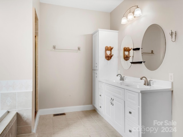 bathroom featuring vanity, tile floors, and tiled tub