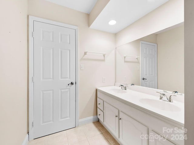 bathroom featuring dual sinks, large vanity, and tile floors