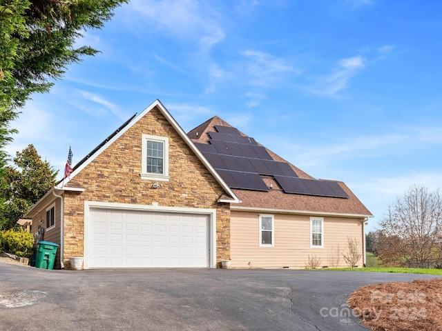 front of property featuring solar panels and a garage