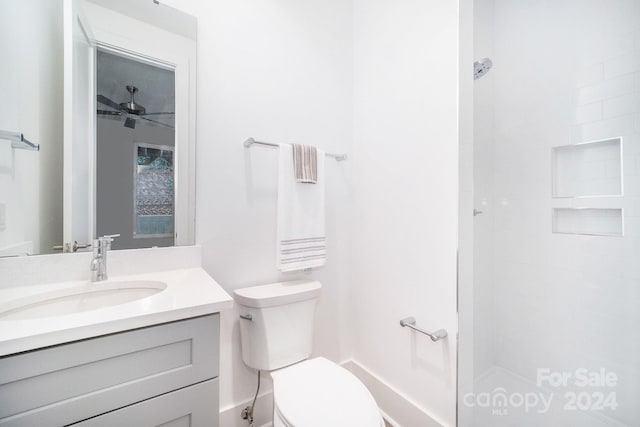 bathroom featuring vanity, ceiling fan, toilet, and walk in shower