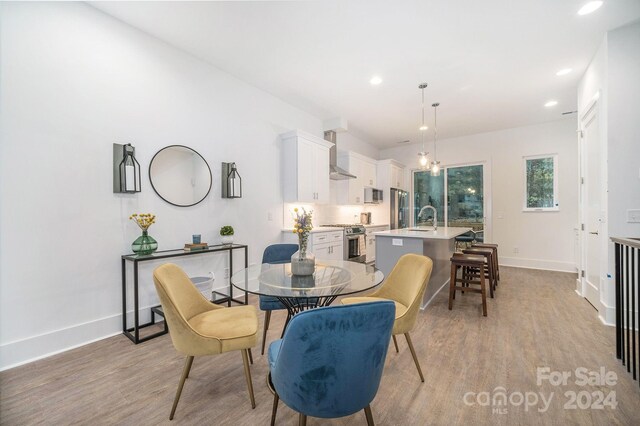 dining area featuring sink and light wood-type flooring