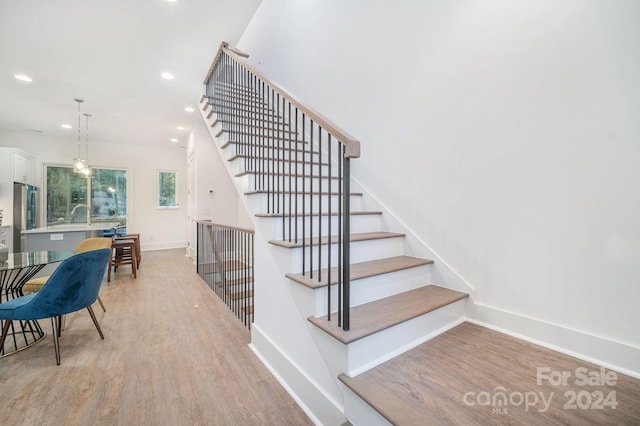 staircase with wood-type flooring and sink