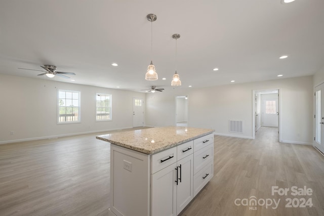 kitchen with white cabinets, ceiling fan, and light hardwood / wood-style floors