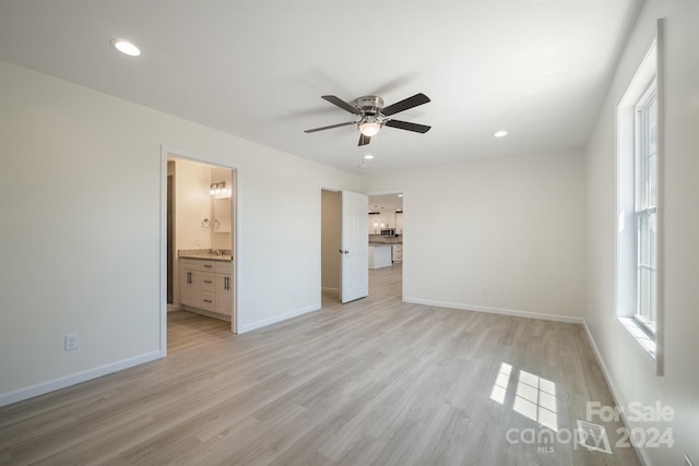 unfurnished bedroom featuring ensuite bath, light hardwood / wood-style flooring, and ceiling fan