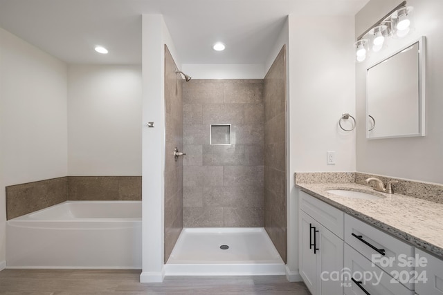 bathroom with independent shower and bath, vanity, and hardwood / wood-style flooring