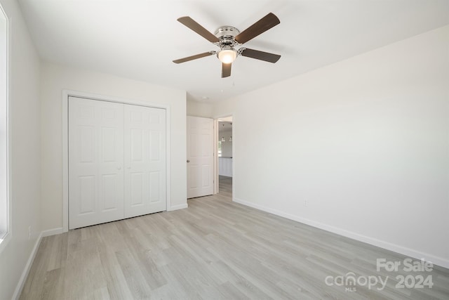 unfurnished bedroom with a closet, ceiling fan, and light wood-type flooring