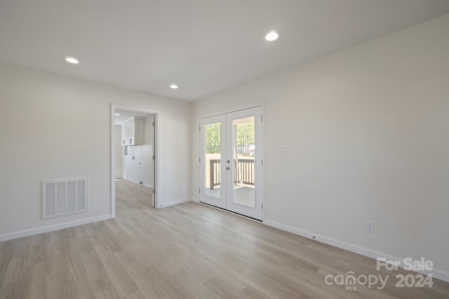 empty room with french doors and light hardwood / wood-style flooring