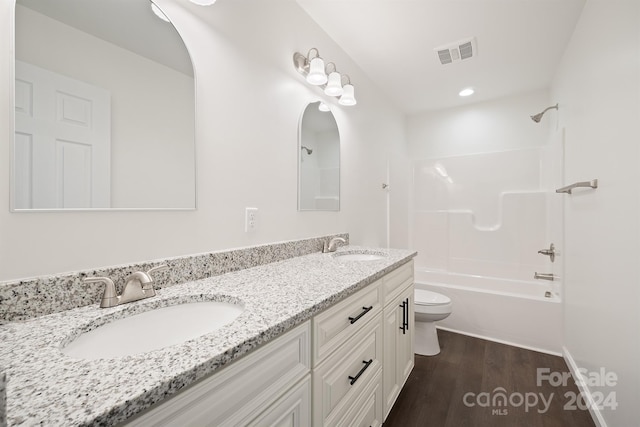 full bathroom with oversized vanity, double sink, toilet, shower / bathtub combination, and hardwood / wood-style flooring