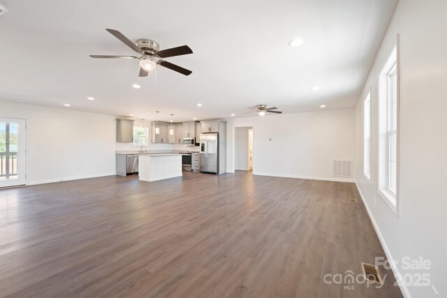 unfurnished living room featuring hardwood / wood-style flooring and ceiling fan