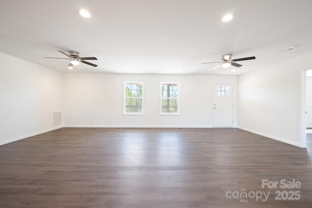 unfurnished living room featuring ceiling fan and dark wood-type flooring