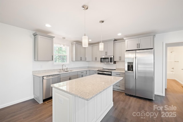 kitchen with hanging light fixtures, stainless steel appliances, gray cabinets, and sink