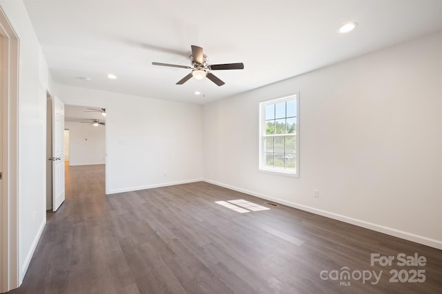 empty room with ceiling fan and dark wood-type flooring