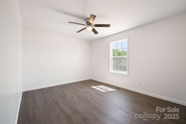 spare room with dark wood-type flooring and ceiling fan