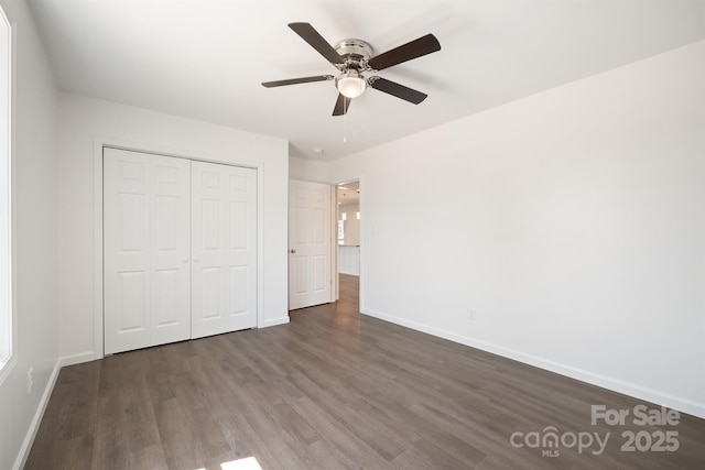 unfurnished bedroom featuring ceiling fan, a closet, and dark hardwood / wood-style flooring