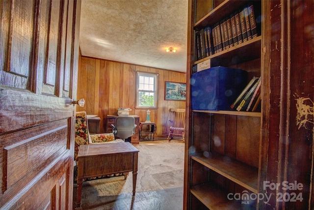 interior space with wooden walls and a textured ceiling