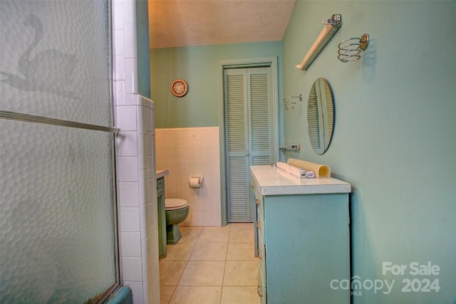 bathroom featuring tile flooring, toilet, tile walls, and vanity