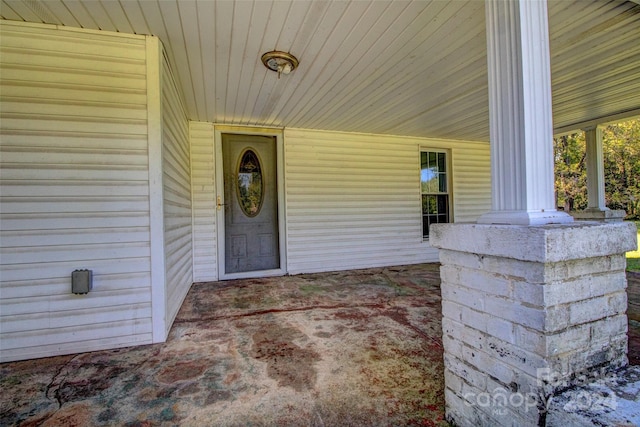 view of exterior entry featuring covered porch