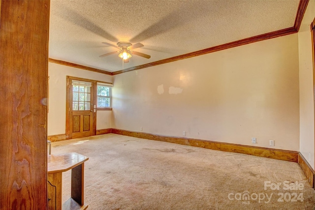 spare room featuring light carpet, ceiling fan, a textured ceiling, and crown molding