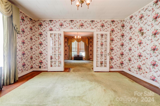 empty room featuring an inviting chandelier, radiator, and wood-type flooring