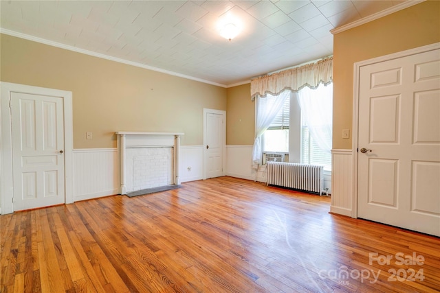 interior space with ornamental molding, hardwood / wood-style flooring, and radiator heating unit