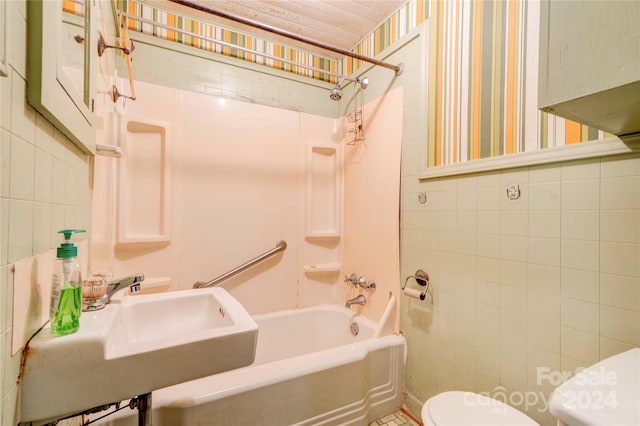 full bathroom featuring toilet, shower / bathing tub combination, tile walls, and sink