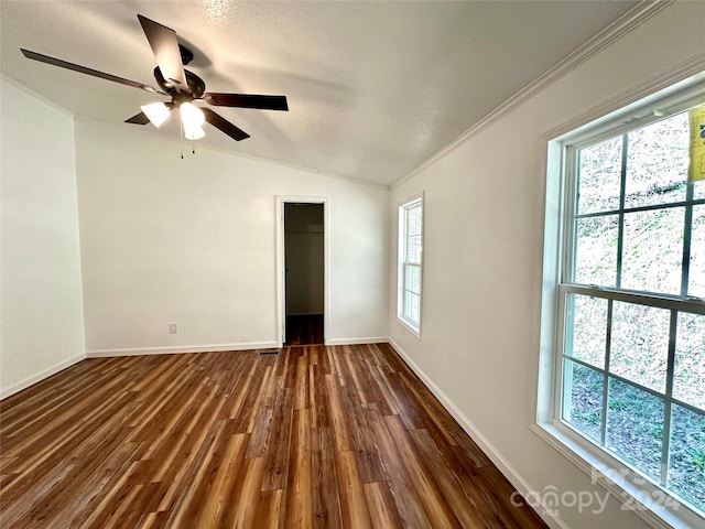 unfurnished room featuring dark hardwood / wood-style floors, ceiling fan, lofted ceiling, and ornamental molding