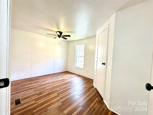 spare room featuring a textured ceiling, dark hardwood / wood-style floors, and ceiling fan