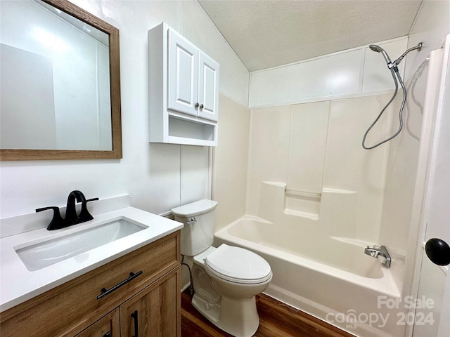 full bathroom with vanity, hardwood / wood-style flooring, toilet, a textured ceiling, and shower / bath combination