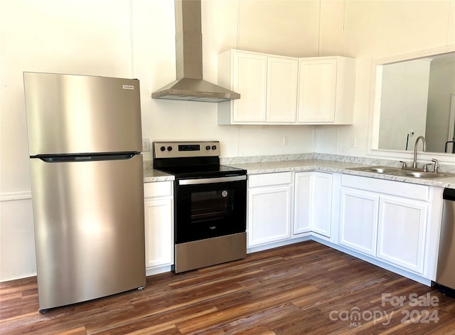 kitchen featuring stainless steel appliances, white cabinetry, and wall chimney exhaust hood